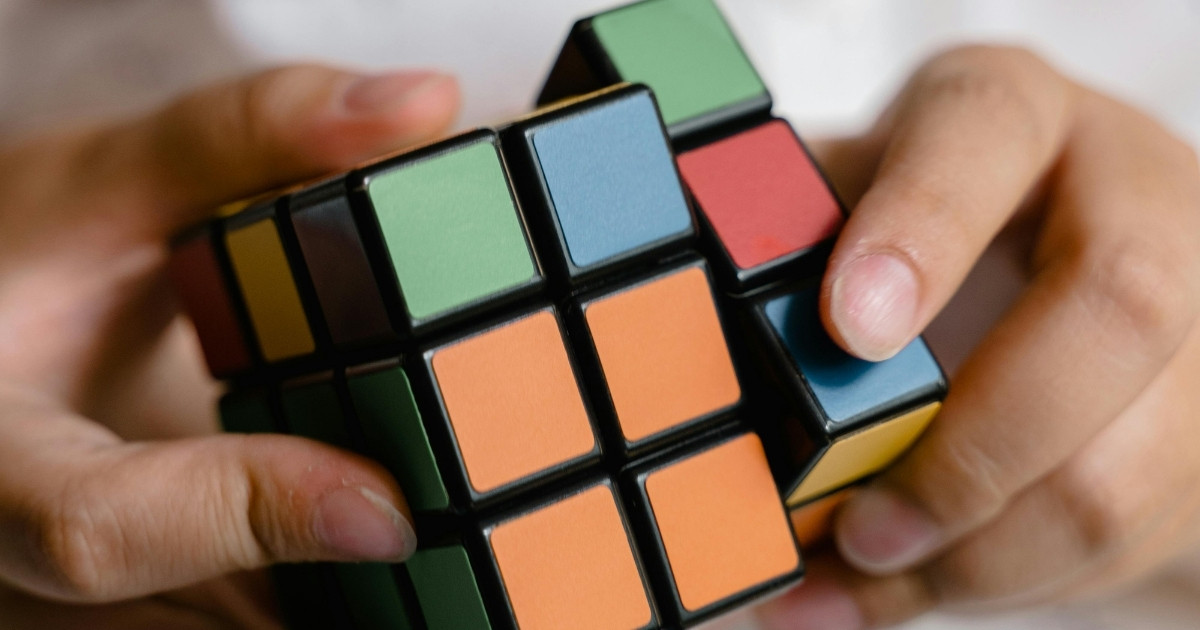 Hände lösen einen Rubik-Würfel — Sinnbild für strukturierte Projektführung